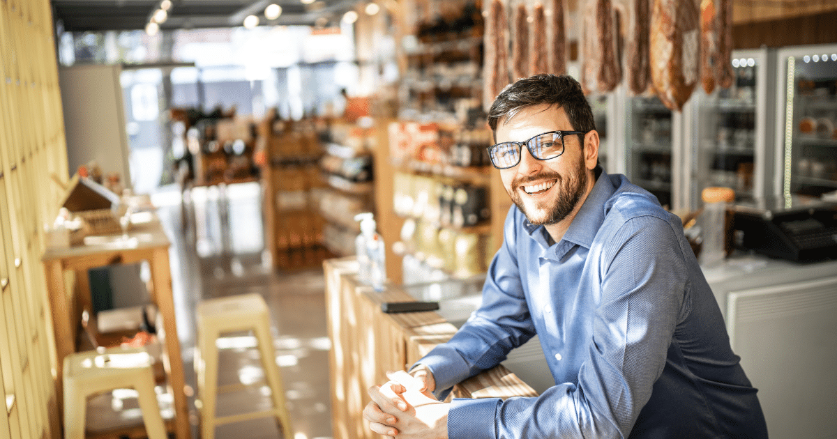 Smiling business owner in a retail store, showcasing flexible credit options for business growth and funding solutions.