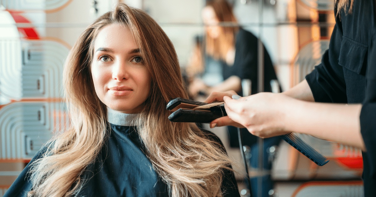 Woman getting her hair styled in a salon, showcasing beauty services and flexible financing options for salons and spas.