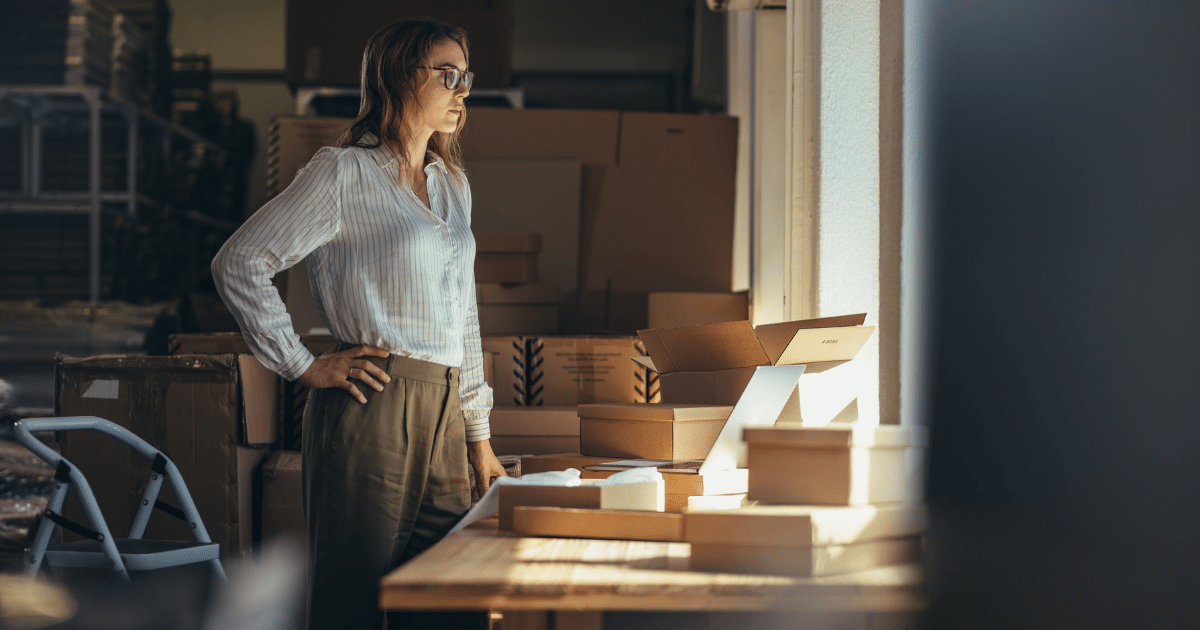 Businesswoman evaluating flexible credit options for real estate investment amidst boxes in a management office.