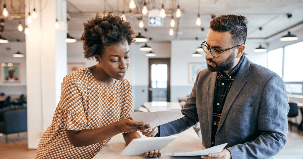 Business professionals discussing pharmacy equipment financing options in a modern office setting.
