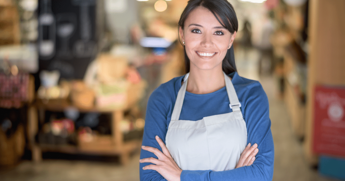 Smiling business owner in an apron, showcasing social media marketing potential for small businesses.