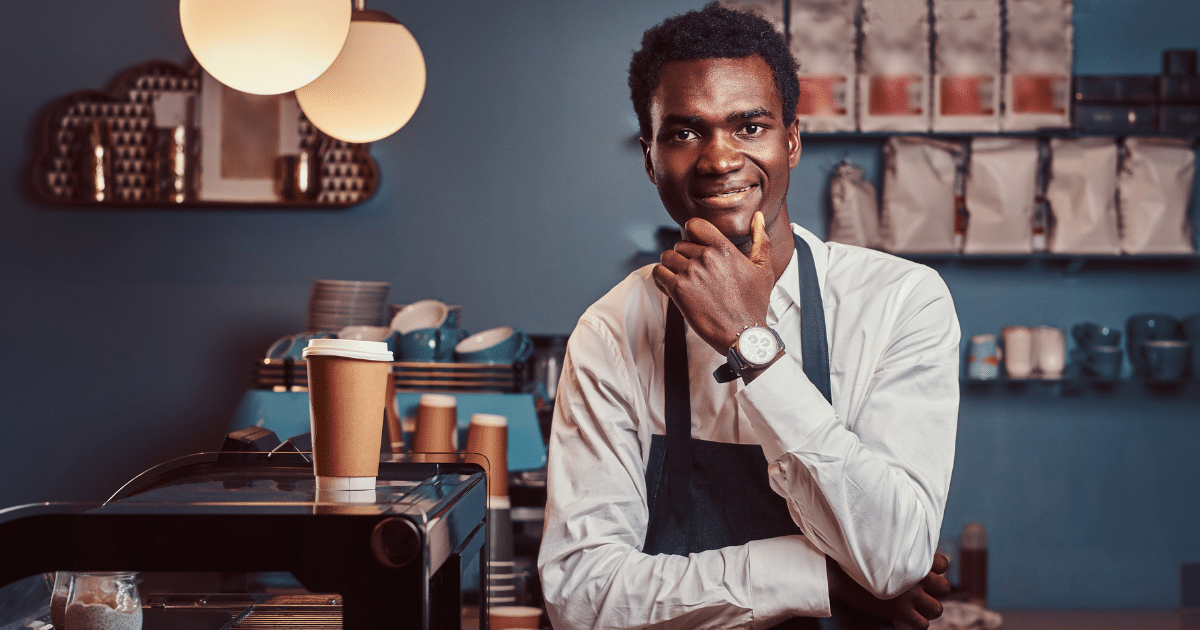 Smiling barista in a coffee shop, representing small business credit building and financing opportunities.