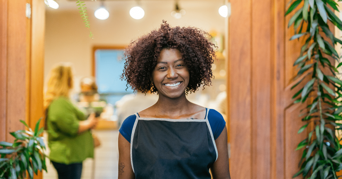 Smiling business owner in an apron, representing loan options for tax payment assistance and financial support.