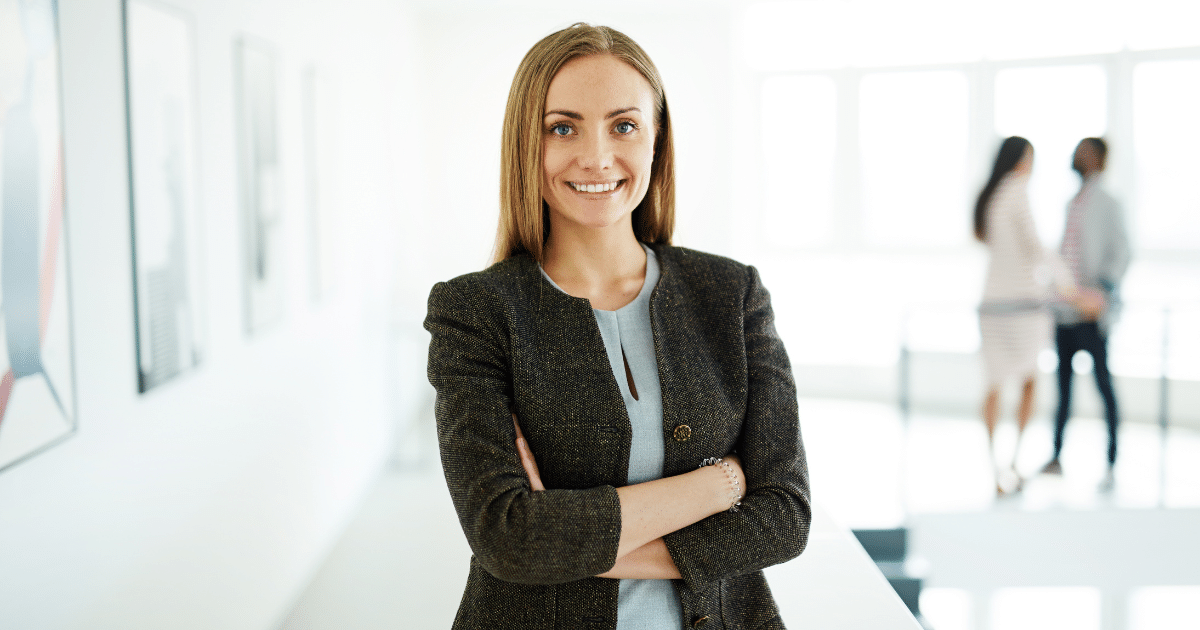 Professional woman smiling confidently in a business setting, representing small business success and social media strategies.