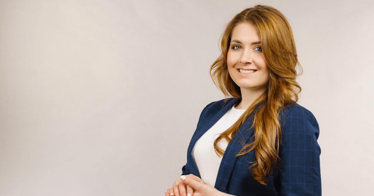 Professional woman smiling in a business suit, representing business credit card management and financial solutions.