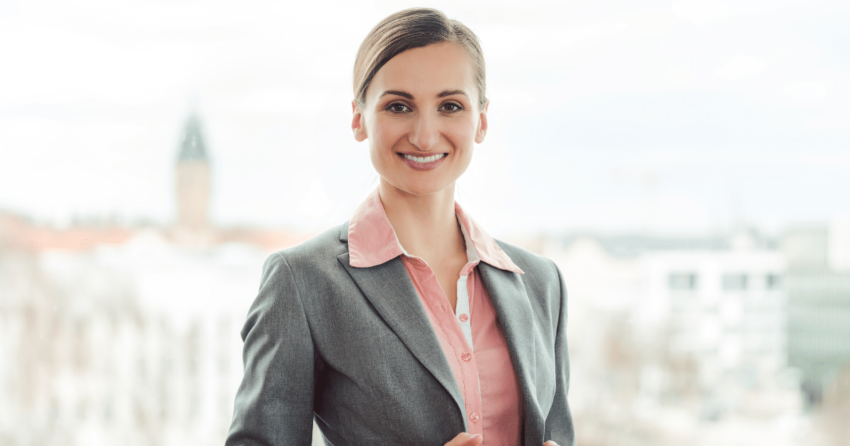 Professional woman smiling in a business suit, representing small business growth and New Year’s resolutions.