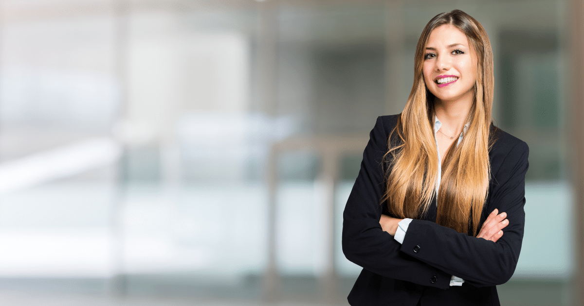 Professional woman in business attire smiling, representing small business loan options and lending trends.