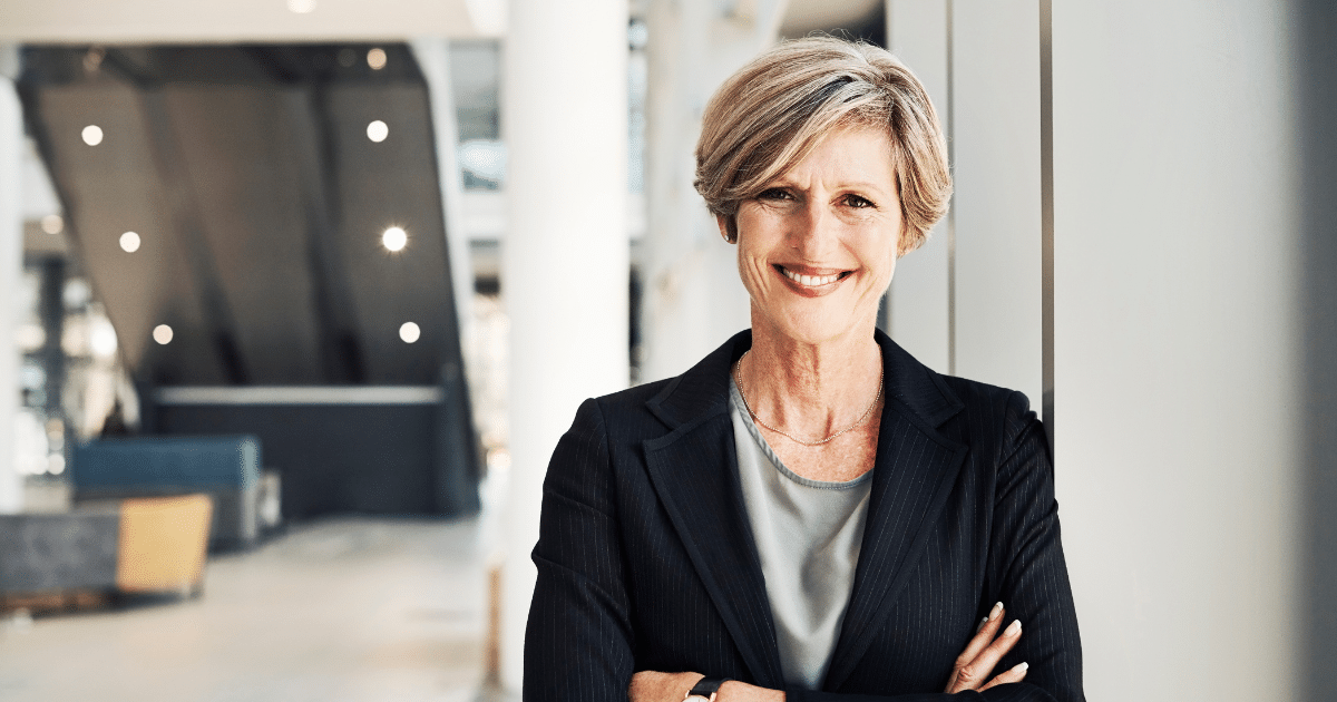 Smiling businesswoman in a professional setting, representing offline marketing strategies for small businesses.