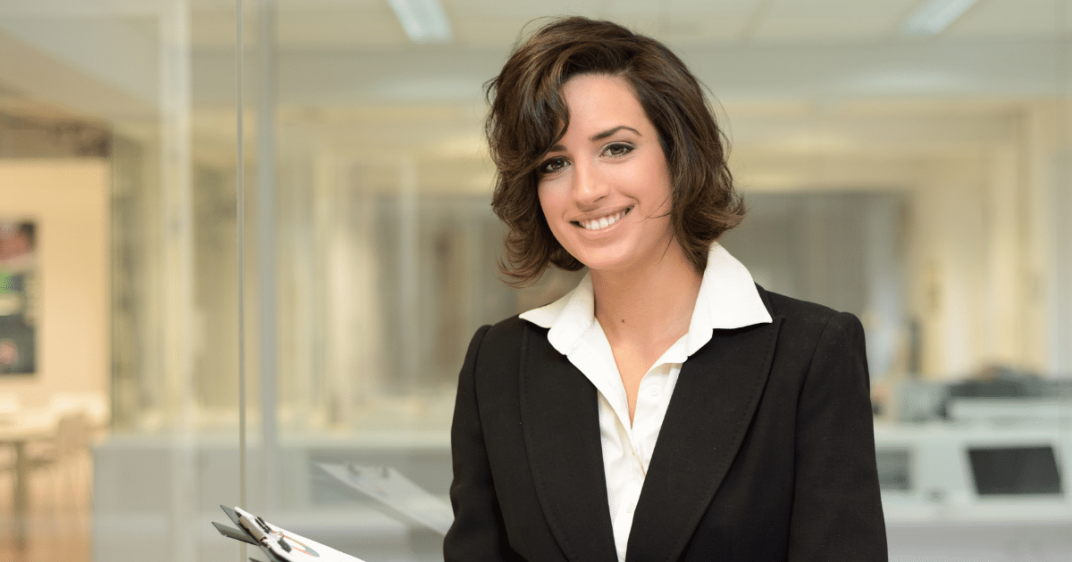 Professional woman in business attire smiling, representing strategic business loans and financial growth opportunities.