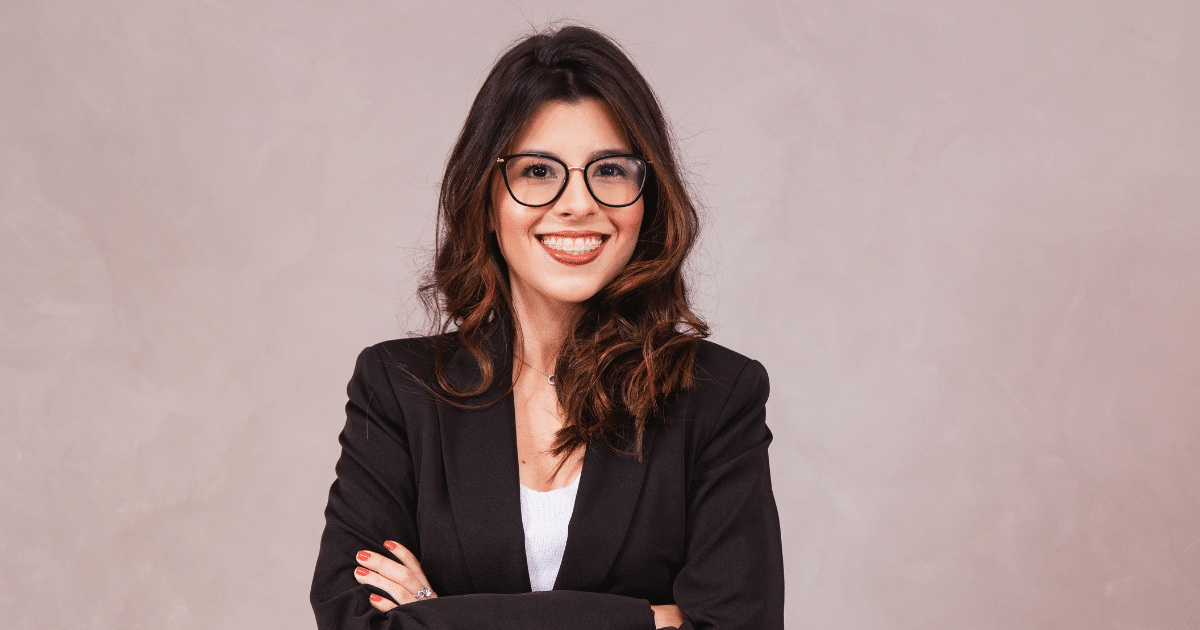 Confident entrepreneur smiling in a professional outfit, embodying success and relationship building in business.