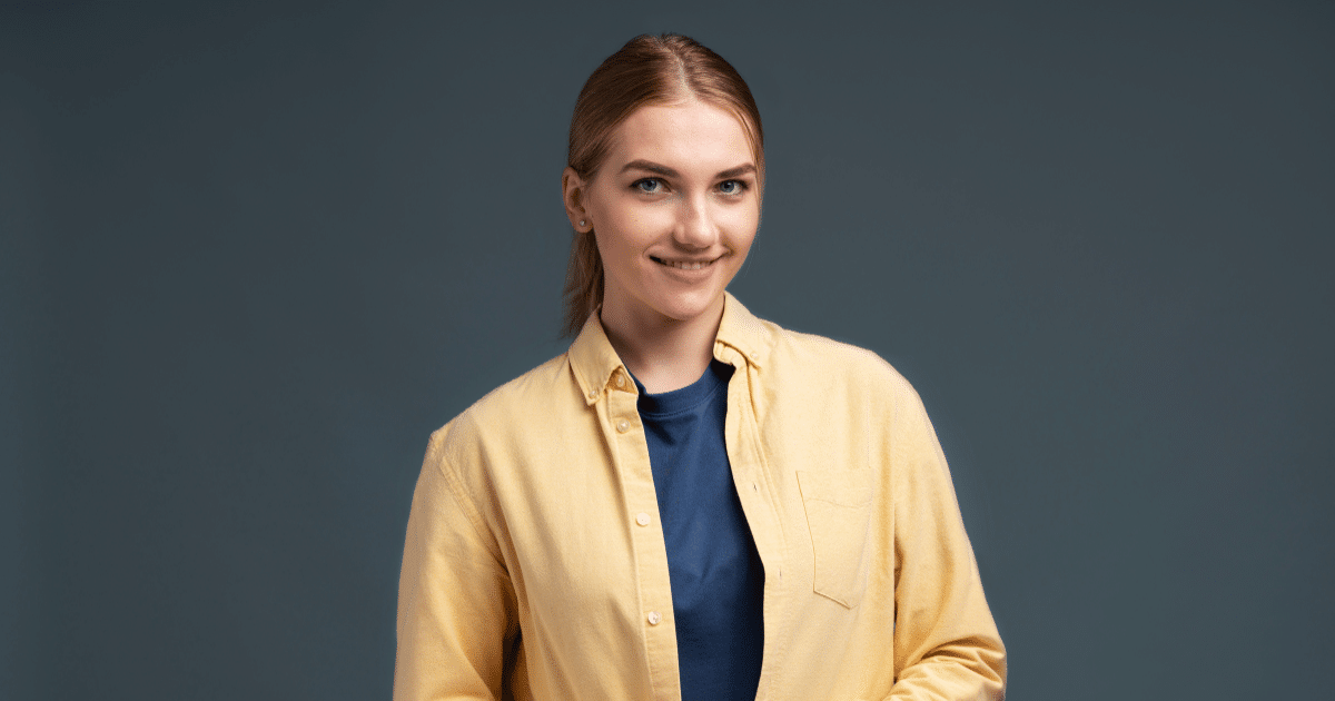 Smiling woman in a yellow shirt, representing financial tips for holiday business preparation.