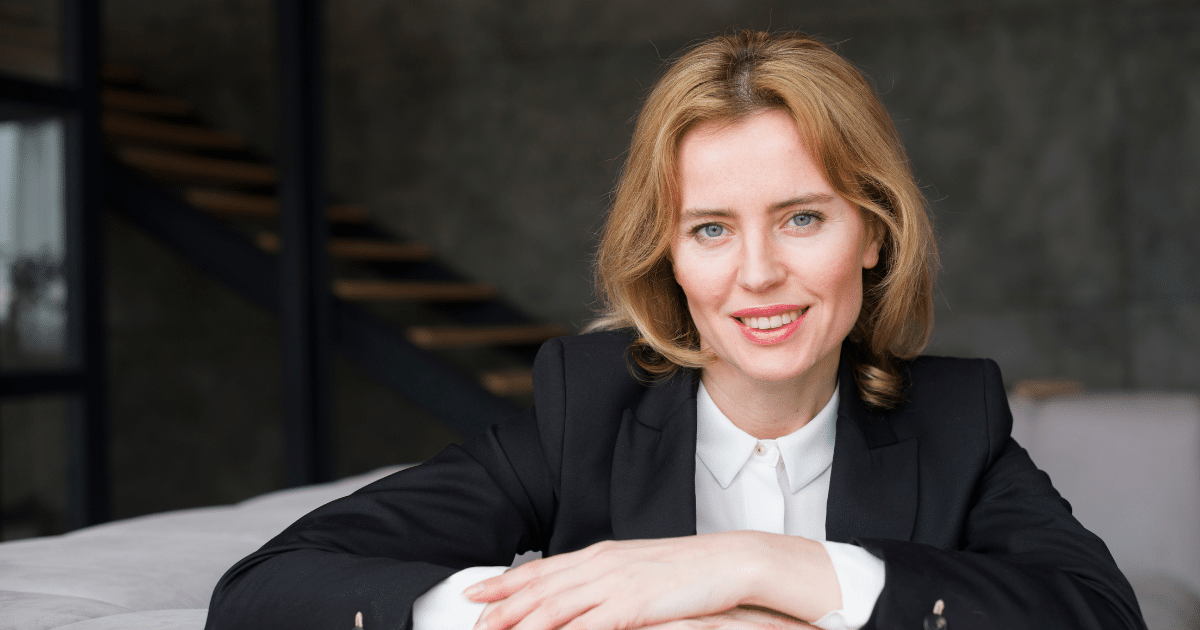 Professional woman smiling in a business setting, representing team building and collaboration activities.