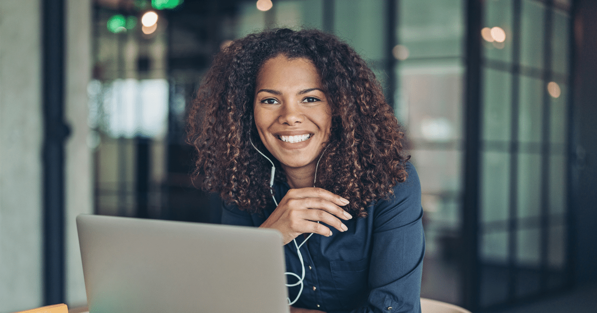 Smiling businesswoman using cloud software on a laptop, showcasing the benefits of cloud computing for small businesses.