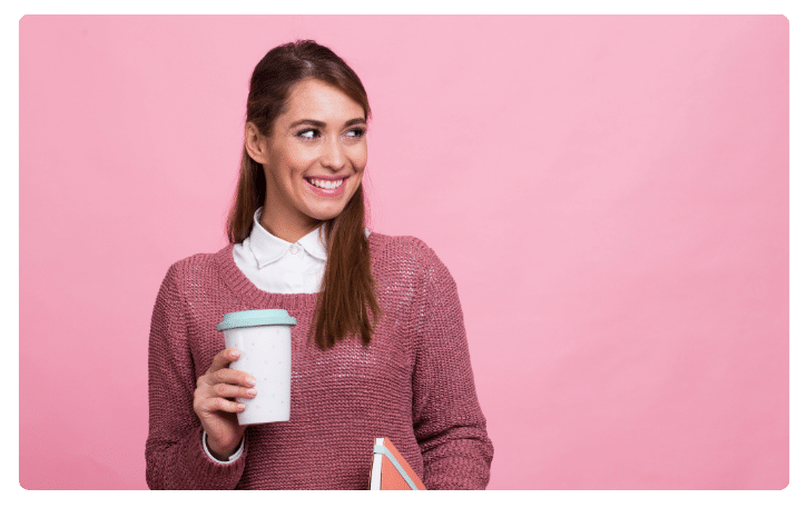 Smiling woman holding a coffee cup and notebook, representing small business empowerment and financing solutions.