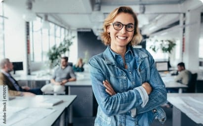 Smiling businesswoman in a modern office, representing HVAC financing solutions and employee empowerment for summer growth.