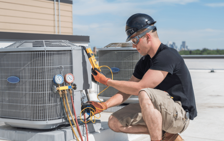 HVAC technician servicing air conditioning units, highlighting summer business growth and financing options for HVAC professionals.