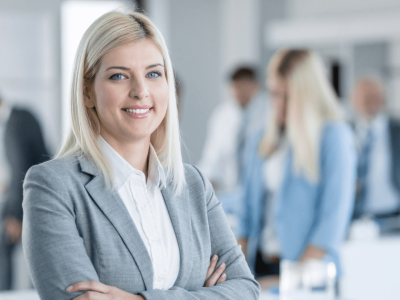 Professional woman smiling in a business setting, representing small business funding and growth opportunities.