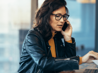 Businesswoman on phone discussing financial solutions for small and medium businesses with bad credit.