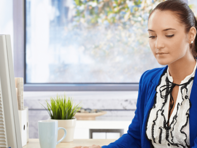 Businesswoman focused on computer security strategies for small business growth in a modern office setting.
