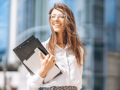 Smiling businesswoman holding a clipboard, representing expert loan consultation for small business growth.