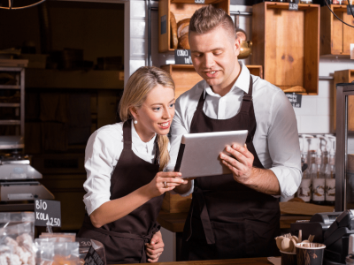 Business owners discussing financial solutions with a tablet, highlighting small business line of credit options.