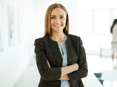 Professional woman smiling confidently in a business setting, representing small business success and social media strategies.