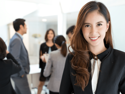 Businesswoman smiling in a professional setting, representing essential apps for small business success and organization.
