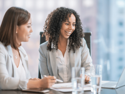 Two businesswomen discussing financing options for small business loans and credit lines in a modern office setting.