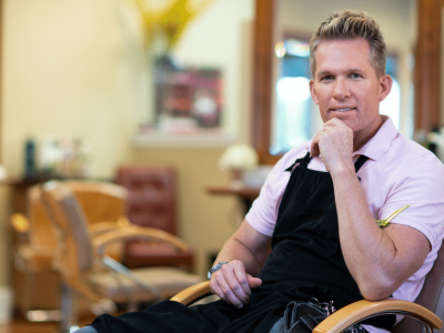 Small business owner in a salon, exploring financing strategies like credit cards and angel investors for growth.