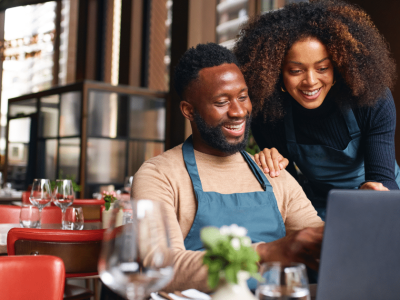 Smiling business owners reviewing financing options for bad credit business loans in California.
