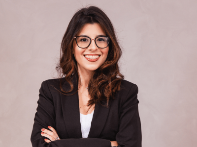 Confident entrepreneur smiling in a professional outfit, embodying success and relationship building in business.