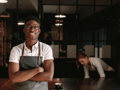 Smiling small business owner in a cafe, showcasing the benefits of flexible lines of credit for growth and cash flow management.
