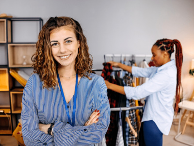 Smiling businesswoman in a clothing store, showcasing affordable financing options for veterinary care loans.