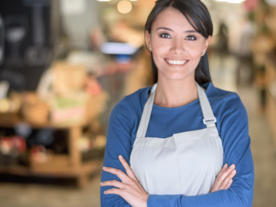 Smiling woman small business owner in an apron, representing American small businesses and entrepreneurship.