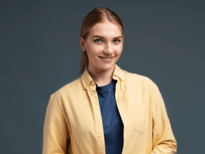 Smiling woman in a yellow shirt, representing financial tips for holiday business preparation.