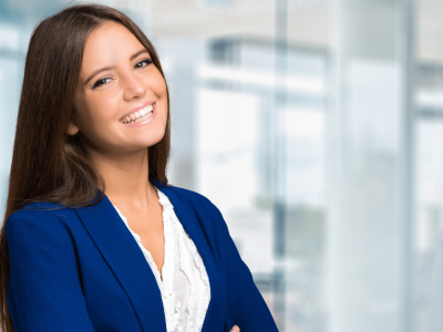 Smiling businesswoman in a blue blazer, representing growth through invoice factoring and loans for companies.
