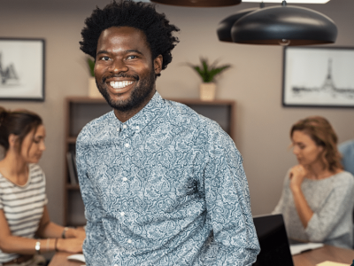Smiling businessman in a modern office, representing flexible purchase order loans for business growth.