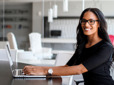 Professional woman using a laptop in a modern office, representing government purchase order financing solutions.