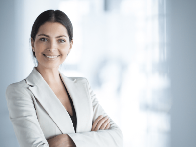 Professional woman smiling in a business setting, representing technology's role in driving economic growth for small businesses.