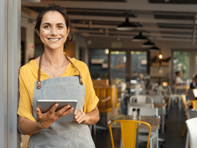 Smiling small business owner in a cafe, showcasing the importance of flexible funding options for bad credit loans.