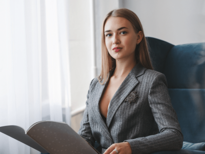 Professional woman in a business suit engaging with corporate materials, symbolizing effective corporate website enhancement.