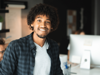 Smiling small business owner in an office, representing unsecured financing and support for SMB credit recovery.