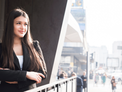 Businesswoman exploring small business financing solutions in a bustling urban environment, showcasing confidence and opportunity.