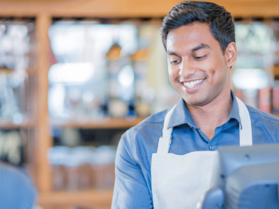 Smiling barista assisting a customer, representing small business growth and financing solutions.