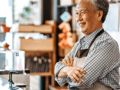 Smiling business owner in a cafe, representing accounts receivable funding for cash flow enhancement and business growth.