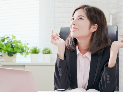 Businesswoman smiling and engaging in effective communication at her desk, promoting teamwork and collaboration.