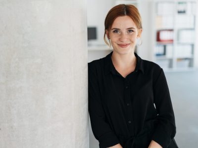 Smiling woman in a black shirt, representing business support and merchant cash advances for entrepreneurs.