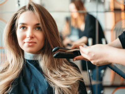 Woman getting her hair styled in a salon, showcasing beauty services and flexible financing options for salons and spas.